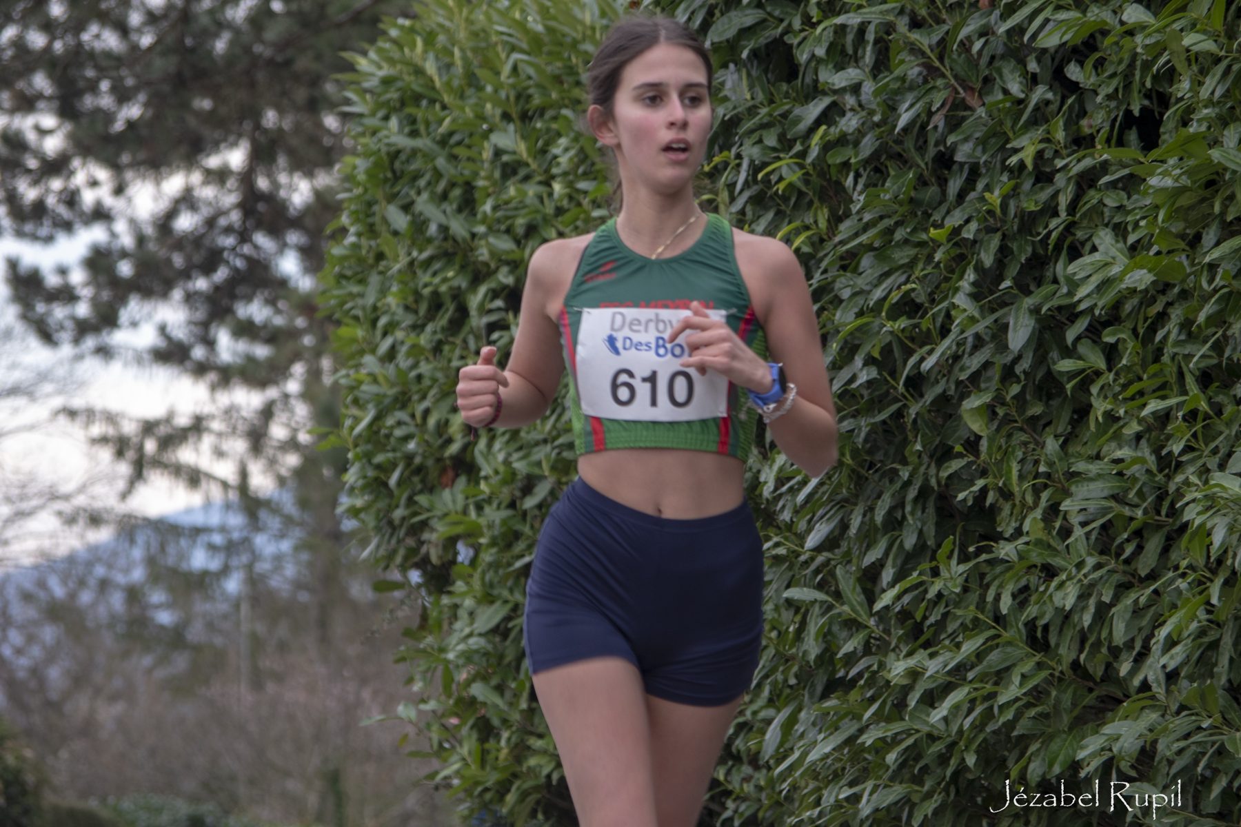 Une coureuse longe une haie le long du parcours