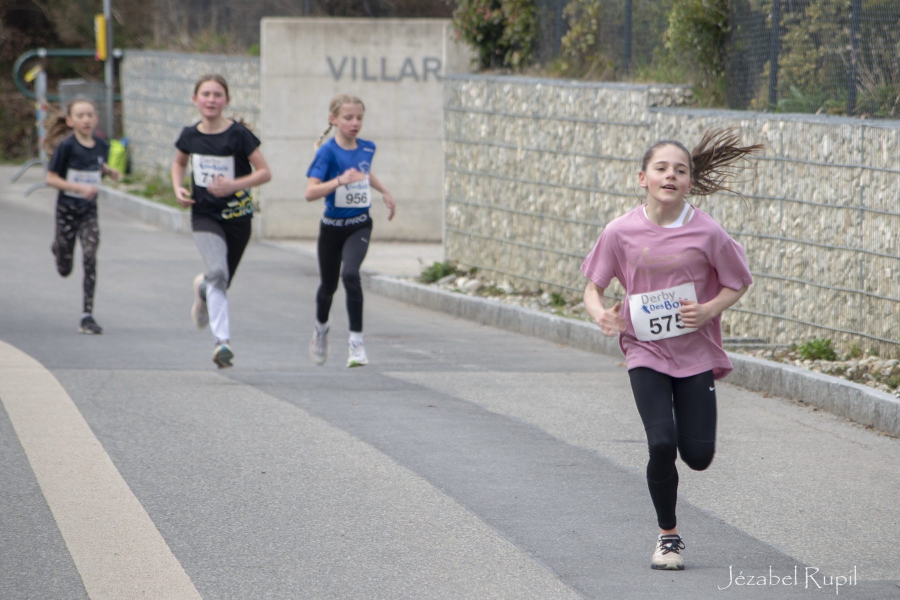 Une jeune coureuse en t-shirt rose mène son groupe
